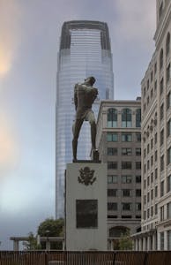 View of a historical monument set against a modern skyscraper in a cityscape.