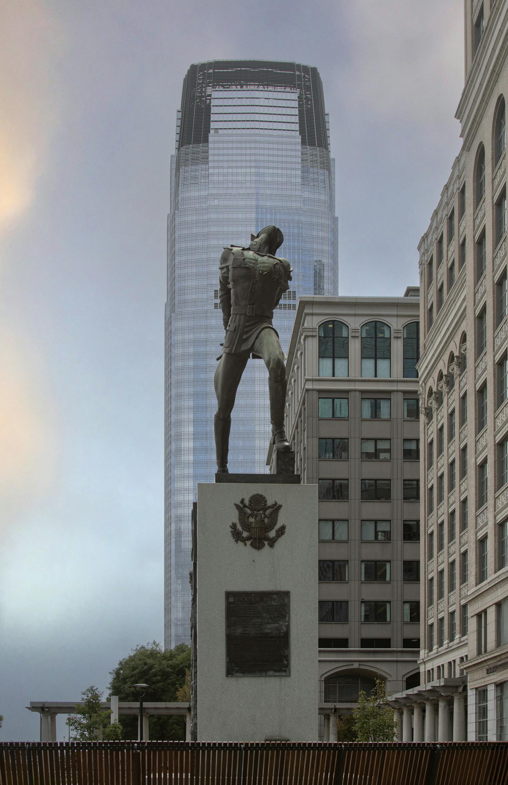 View of a historical monument set against a modern skyscraper in a cityscape.